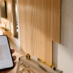 Habillage mur interieur moderne bois et PVC dans un salon